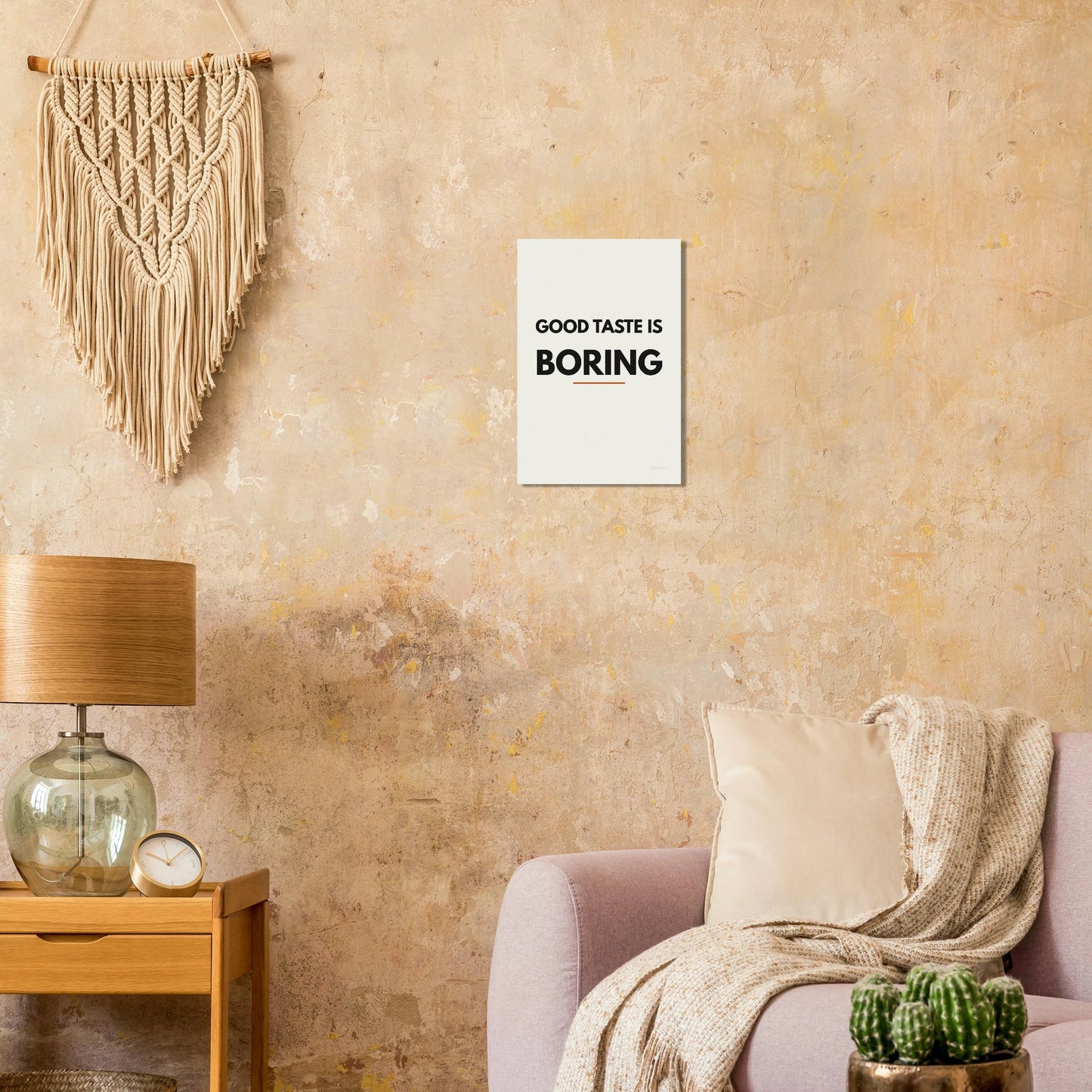 Good Taste Is Boring typography poster on a warm textured wall with lamp and armchair