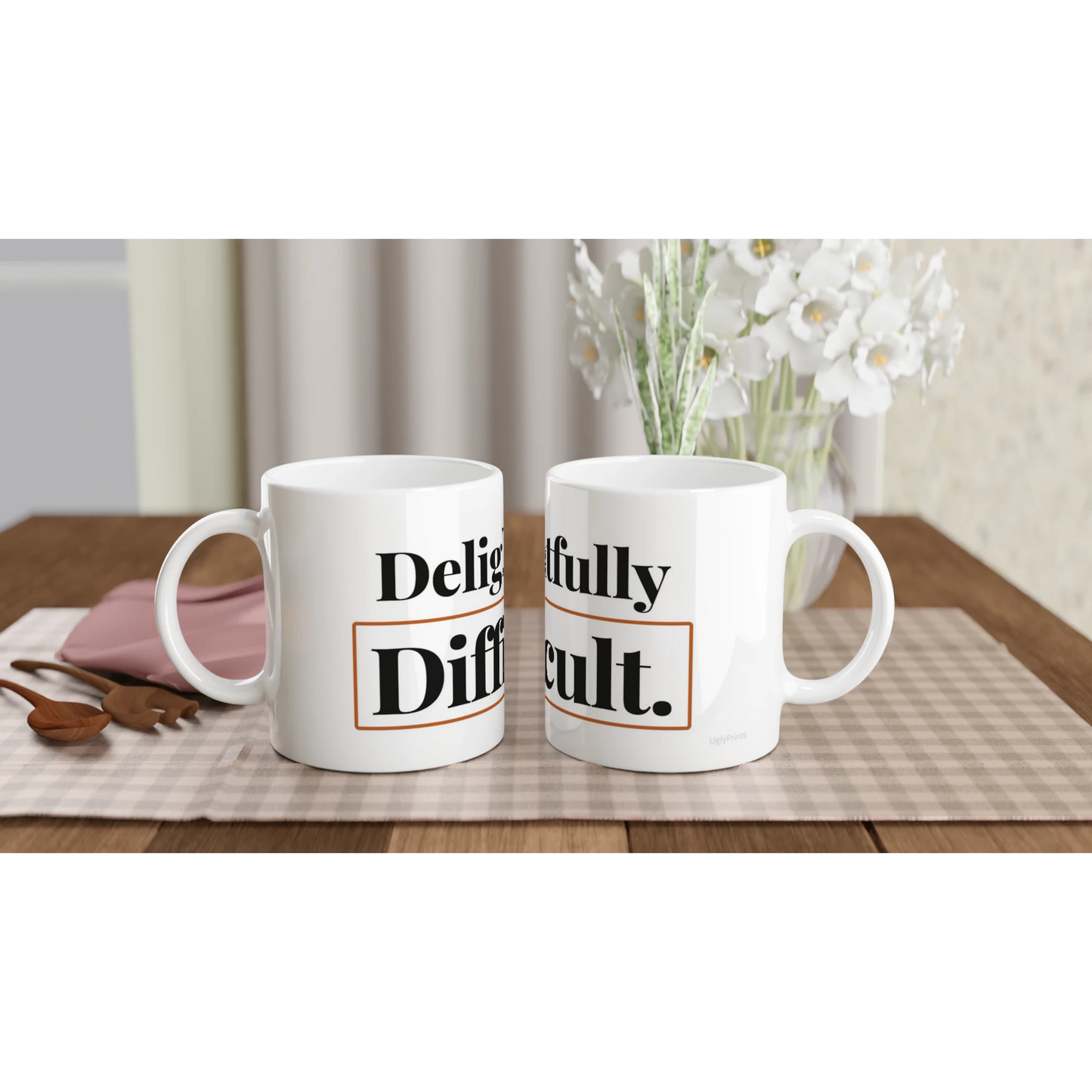 Delightfully Difficult funny typography mugs on table with flowers lifestyle setting