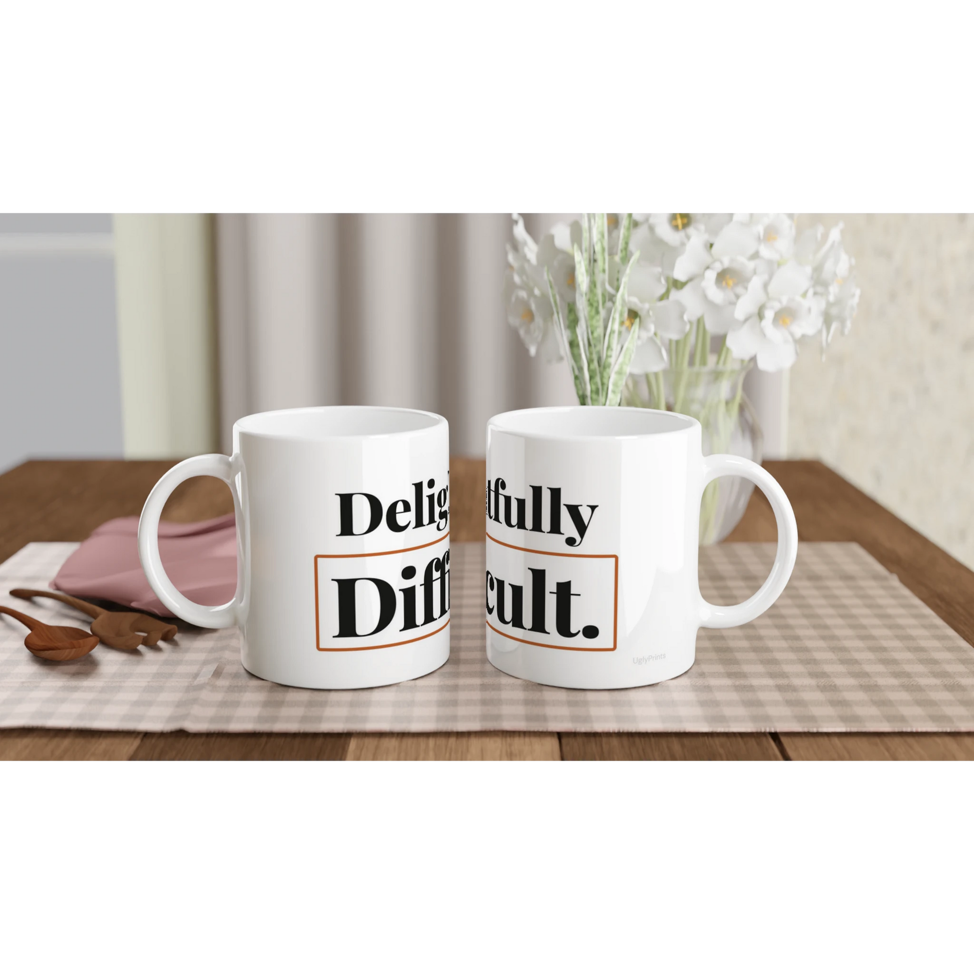 Delightfully Difficult funny typography mugs on table with flowers lifestyle setting