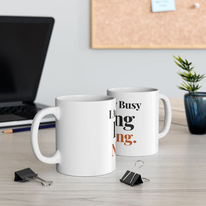 I Am Very Busy Doing Nothing funny typography mugs on a modern office desk with laptop cork board and plant