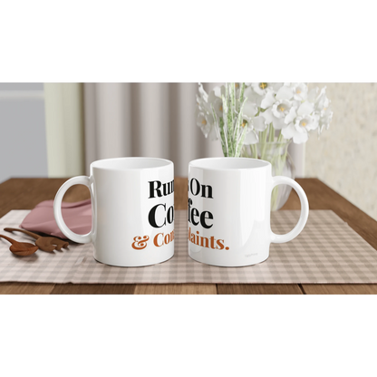 Runs On Coffee And Complaints funny typography mugs on table with flowers lifestyle setting