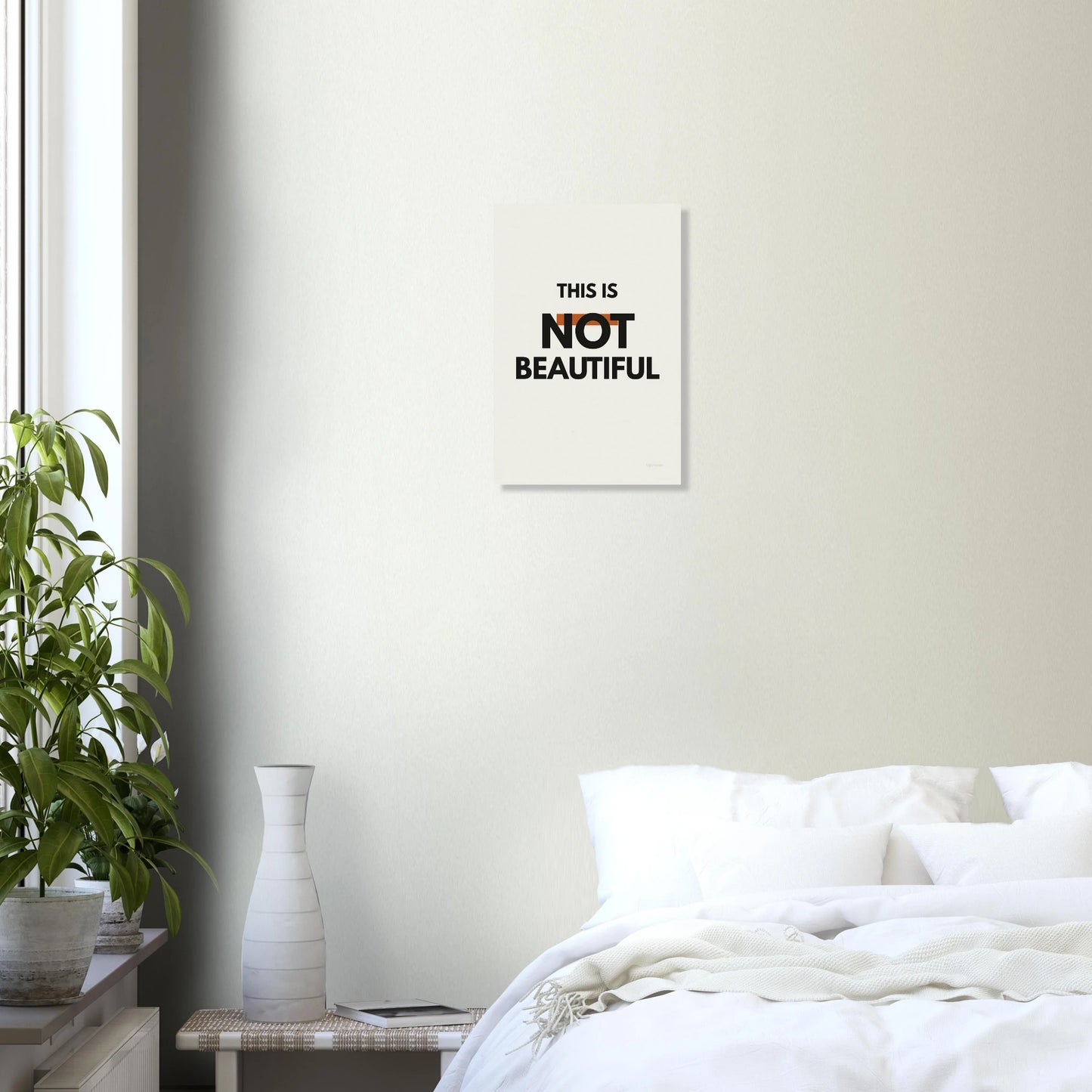 This Is Not Beautiful typography poster in a bright bedroom with white walls and green plant