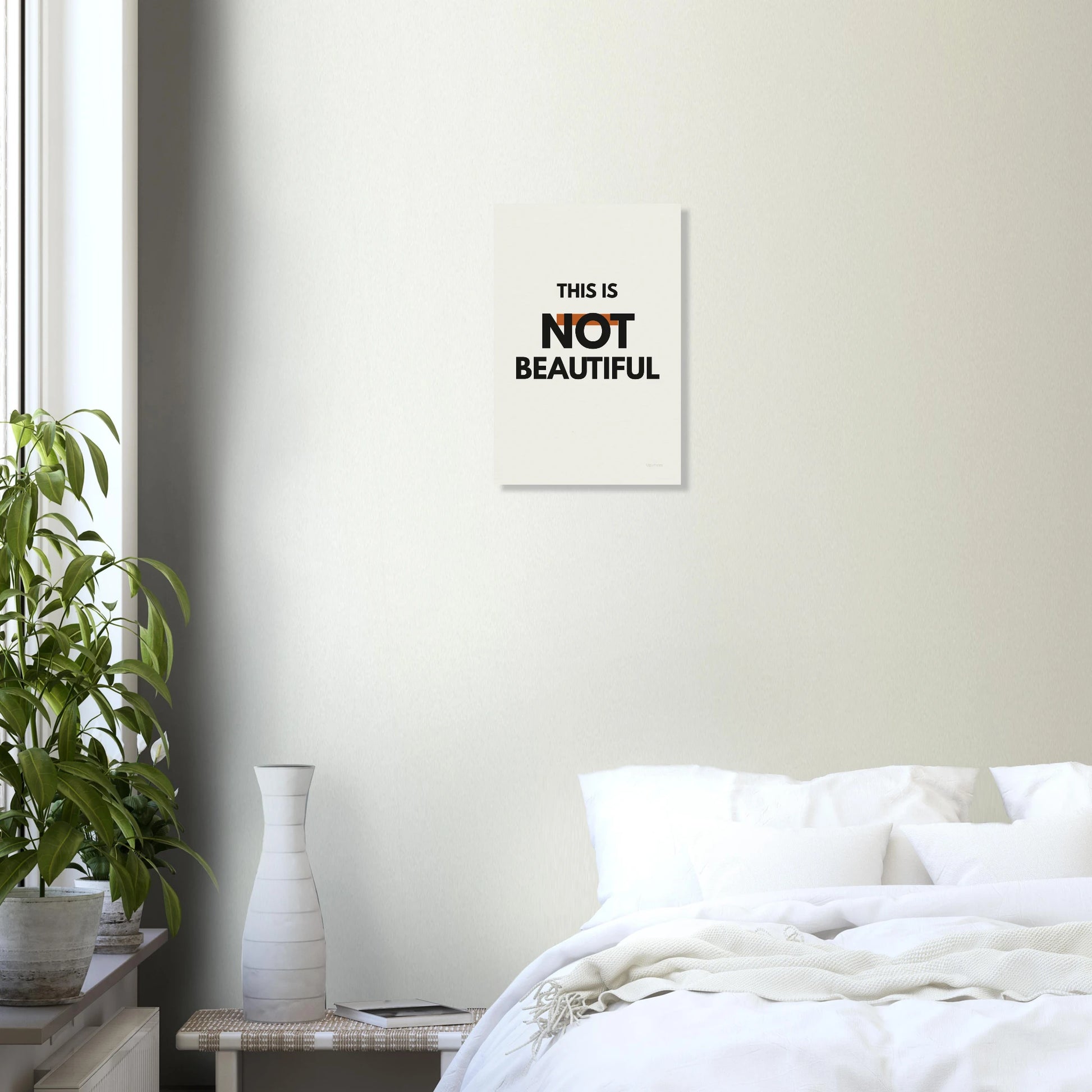 This Is Not Beautiful typography poster in a bright bedroom with white walls and green plant