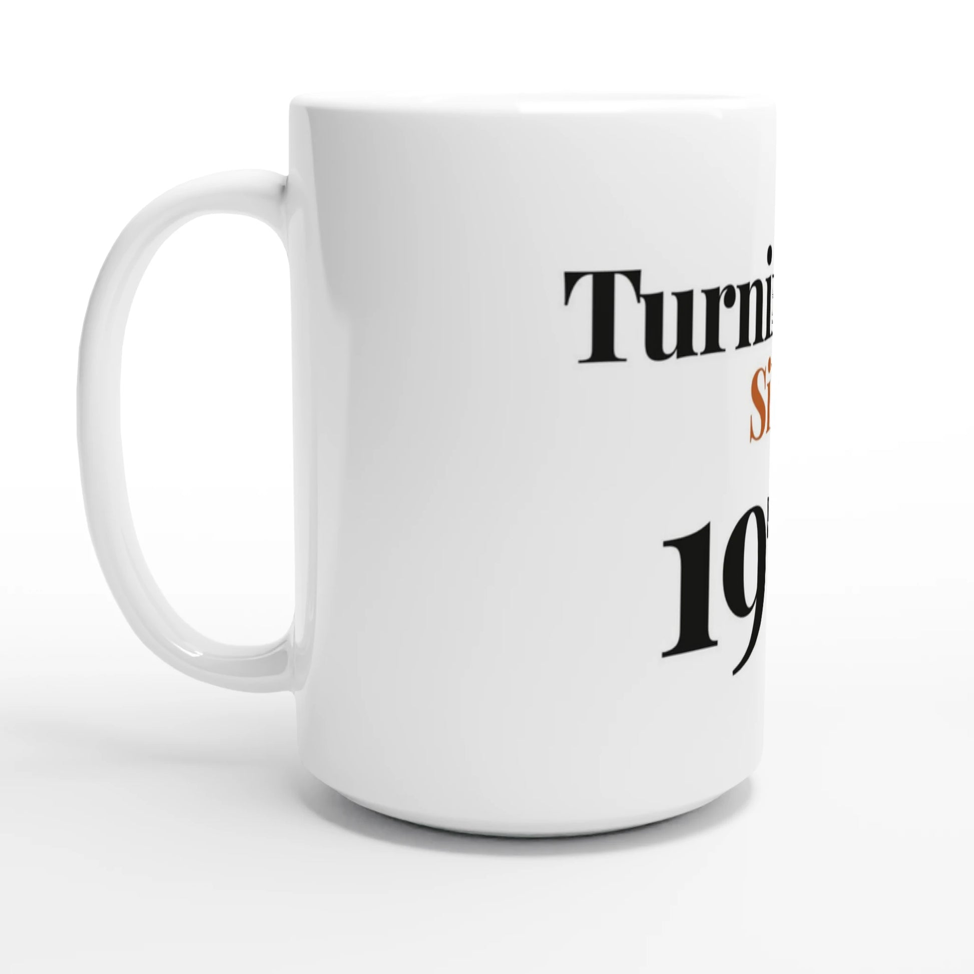 Turning Fine Since 1976 — 15oz white ceramic funny birthday mug angled side view