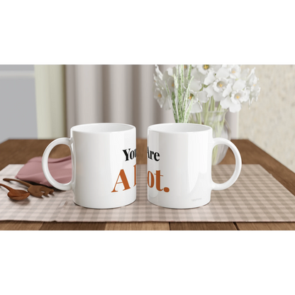 You Are A Lot funny typography mugs on table with flowers lifestyle setting